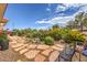 Tranquil backyard featuring desert landscaping, a stone walkway, and a black bench at 10537 Shoalhaven Dr, Las Vegas, NV 89134