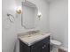 Powder room featuring a sink with marble counter and a black vanity at 10537 Shoalhaven Dr, Las Vegas, NV 89134