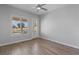 Bright bedroom features wood-style floors, ceiling fan, shuttered windows, and patio door at 10537 Shoalhaven Dr, Las Vegas, NV 89134