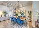 Dining room features a modern light fixture, live-edge dining table, and blue chairs at 10537 Shoalhaven Dr, Las Vegas, NV 89134