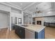 Open-concept kitchen with stainless appliances, island, stone fireplace, and custom cabinets at 10537 Shoalhaven Dr, Las Vegas, NV 89134