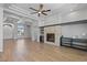 Living room features a stone fireplace, ceiling fan, built-in shelves, and wood floors at 10537 Shoalhaven Dr, Las Vegas, NV 89134