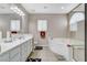 Bright bathroom featuring a dual sink vanity, soaking tub, and glass-enclosed shower at 10657 Medicine Bow St, Las Vegas, NV 89183