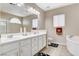 Bathroom features double sinks with a large mirror and a soaking tub with a shower at 10657 Medicine Bow St, Las Vegas, NV 89183