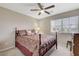 Cozy bedroom with a decorative bed frame, ceiling fan, and bright window at 10657 Medicine Bow St, Las Vegas, NV 89183