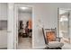 Bedroom featuring open doors to walk-in closet and ensuite bathroom, and a rocking chair at 10657 Medicine Bow St, Las Vegas, NV 89183