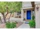 Inviting front porch with bench seating, a blue door, and a well-maintained garden at 10657 Medicine Bow St, Las Vegas, NV 89183