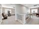 Upstairs hallway with neutral carpet leads to rooms and provides clear views with glass railing at 10657 Medicine Bow St, Las Vegas, NV 89183