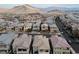 Expansive aerial shot showcasing the neighborhood's layout, complete with streets, houses, and scenic mountain views at 10936 White Alder Pl, Las Vegas, NV 89138