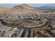 Community aerial view with mountains, swimming pool and surrounding neighborhood amenities in a desert landscape at 10936 White Alder Pl, Las Vegas, NV 89138