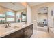 Bathroom featuring double sinks, a soaking tub, tile flooring, with a view of the main bedroom at 10936 White Alder Pl, Las Vegas, NV 89138