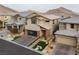 Aerial view of a modern stucco house with a glass garage door, stylish landscaping, and mountains in the background at 10936 White Alder Pl, Las Vegas, NV 89138