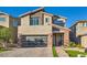 Charming two-story home featuring a contemporary design, brick accents, and manicured front yard with modern garage at 10936 White Alder Pl, Las Vegas, NV 89138