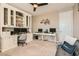 Home office featuring built-in cabinetry, multiple desks, carpet flooring, and neutral walls at 10936 White Alder Pl, Las Vegas, NV 89138
