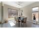 Bright dining room with a modern ceiling fan, large windows, tile floors, and a dining table set for six at 11161 Black Fire Opal Dr, Las Vegas, NV 89138
