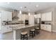 Modern kitchen featuring white cabinets, granite countertops, stainless steel appliances, and a kitchen island with seating at 11161 Black Fire Opal Dr, Las Vegas, NV 89138