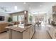 Contemporary kitchen with granite counters, stainless appliances, an island with seating, and an open view to the living and dining areas at 11161 Black Fire Opal Dr, Las Vegas, NV 89138