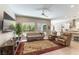 Comfortable living room with a modern ceiling fan, plush seating, and large windows overlooking the backyard at 11161 Black Fire Opal Dr, Las Vegas, NV 89138