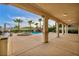Expansive covered patio overlooking a lush backyard with pool, spa, rock feature, and palm trees at 12283 Lost Treasure Ave, Las Vegas, NV 89138
