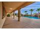 Spacious covered patio with views of the pool area, rock features, palm trees, and manicured greenery at 12283 Lost Treasure Ave, Las Vegas, NV 89138
