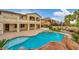 Beautiful backyard with a pool, spa, rock waterfall, outdoor kitchen, lounge area, and lush landscaping to enjoy backyard living at 12283 Lost Treasure Ave, Las Vegas, NV 89138