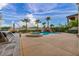 Beautiful backyard with a pool, spa, rock waterfall feature, outdoor kitchen, lounge area, and lush landscaping at 12283 Lost Treasure Ave, Las Vegas, NV 89138