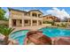 Lush backyard with a pool, spa, rock waterfall, outdoor kitchen, patio, and plenty of space for outdoor living and entertaining at 12283 Lost Treasure Ave, Las Vegas, NV 89138