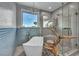 A modern bathroom features a standalone tub, glass shower, tile accent wall, and mountain views at 12283 Lost Treasure Ave, Las Vegas, NV 89138