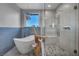 A modern bathroom features a standalone tub, glass shower, tile accent wall, and mountain views at 12283 Lost Treasure Ave, Las Vegas, NV 89138