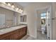 Bathroom featuring double sinks, warm wood cabinets, large mirror, and a separate toilet room at 12283 Lost Treasure Ave, Las Vegas, NV 89138