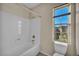 Bright bathroom with a shower-tub combo, toilet, and a window with natural light and neighborhood views at 12283 Lost Treasure Ave, Las Vegas, NV 89138