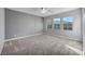 Bright bedroom with a decorative accent wall, gray carpet, three windows, and ample space at 12283 Lost Treasure Ave, Las Vegas, NV 89138