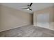 Well-lit bedroom featuring gray carpet, a ceiling fan, and a closet with white sliding doors at 12283 Lost Treasure Ave, Las Vegas, NV 89138