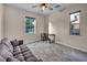 Bedroom has a ceiling fan, two windows, carpet, and a sofa and desk at 12283 Lost Treasure Ave, Las Vegas, NV 89138