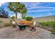 Relaxing patio area with comfortable seating, a fire pit, lush plants, and a block wall for privacy in this backyard retreat at 12283 Lost Treasure Ave, Las Vegas, NV 89138