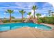 Backyard swimming pool featuring custom rock waterfall, mature palm trees, and lush landscaping at 12283 Lost Treasure Ave, Las Vegas, NV 89138