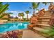 Outdoor swimming pool featuring custom rock waterfall and lush landscaping in backyard at 12283 Lost Treasure Ave, Las Vegas, NV 89138