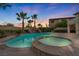 Gorgeous backyard pool and spa with a rock waterfall feature, palm trees, and ample space for entertaining under the sunset at 12283 Lost Treasure Ave, Las Vegas, NV 89138