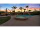 Inviting backyard pool with a waterfall feature, spa, and comfortable seating area surrounded by lush landscaping and palm trees at 12283 Lost Treasure Ave, Las Vegas, NV 89138