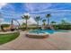 Resort-style backyard with a swimming pool, spa, rock waterfall, green grass area, outdoor seating, and desert landscaping at 12283 Lost Treasure Ave, Las Vegas, NV 89138