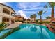 Inviting backyard oasis featuring a sparkling pool, rock waterfall, palm trees, and spa at 12283 Lost Treasure Ave, Las Vegas, NV 89138
