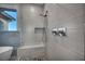 Glass enclosed shower featuring gray tile surround, bench, handheld shower head, and accent tile design at 12283 Lost Treasure Ave, Las Vegas, NV 89138