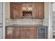 Wet bar with dark wood cabinets, beverage fridge, and tile backsplash at 12283 Lost Treasure Ave, Las Vegas, NV 89138