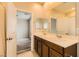 Bathroom featuring dual sinks, a large mirror, and an adjacent bedroom view at 130 Mountain Cedar Ct, North Las Vegas, NV 89031
