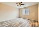 Cozy bedroom with wood-look flooring, a ceiling fan, and ample natural light from the window at 130 Mountain Cedar Ct, North Las Vegas, NV 89031