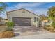 Beautiful single-story home with a tile roof, stucco exterior, and brick driveway leading to a spacious two-car garage at 130 Mountain Cedar Ct, North Las Vegas, NV 89031