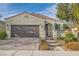 Inviting single-story home boasts a tile roof, neutral stucco, and a brick driveway leading to a spacious two-car garage at 130 Mountain Cedar Ct, North Las Vegas, NV 89031