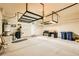 Spacious garage featuring overhead storage, built-in desk, and two blue recycling bins at 130 Mountain Cedar Ct, North Las Vegas, NV 89031