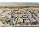 An aerial view showcases the neighborhood, houses, and surrounding desert landscape at 132 Soaring Sky Ave, Henderson, NV 89011