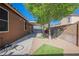 A backyard featuring a covered patio, gravel, artificial grass, and a tree at 132 Soaring Sky Ave, Henderson, NV 89011